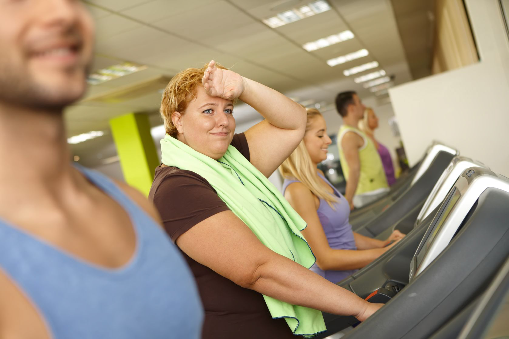 38380863 – exhausted fat woman training on running machine in gym.